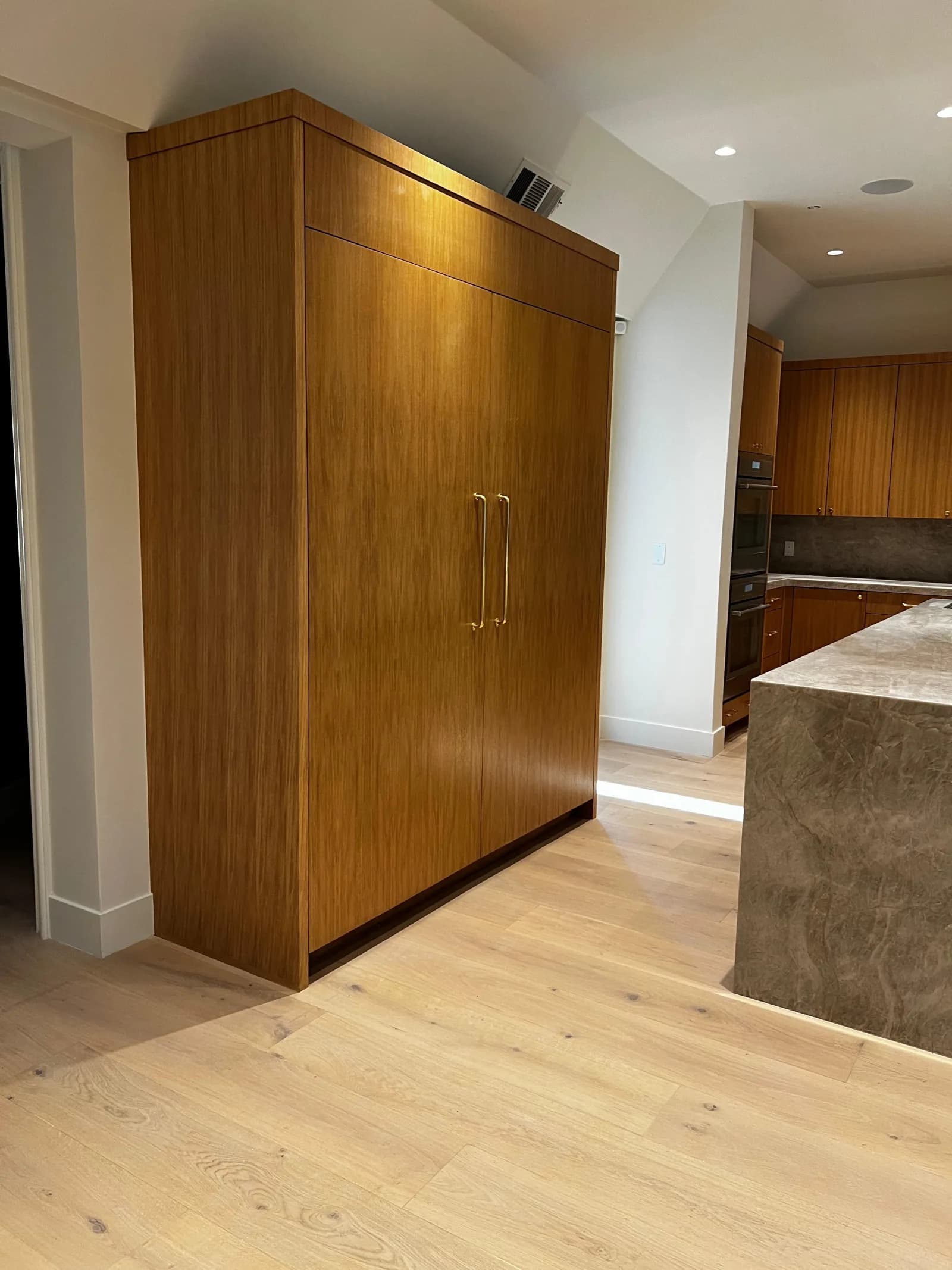 Built-in wood pantry with hardwood plank flooring