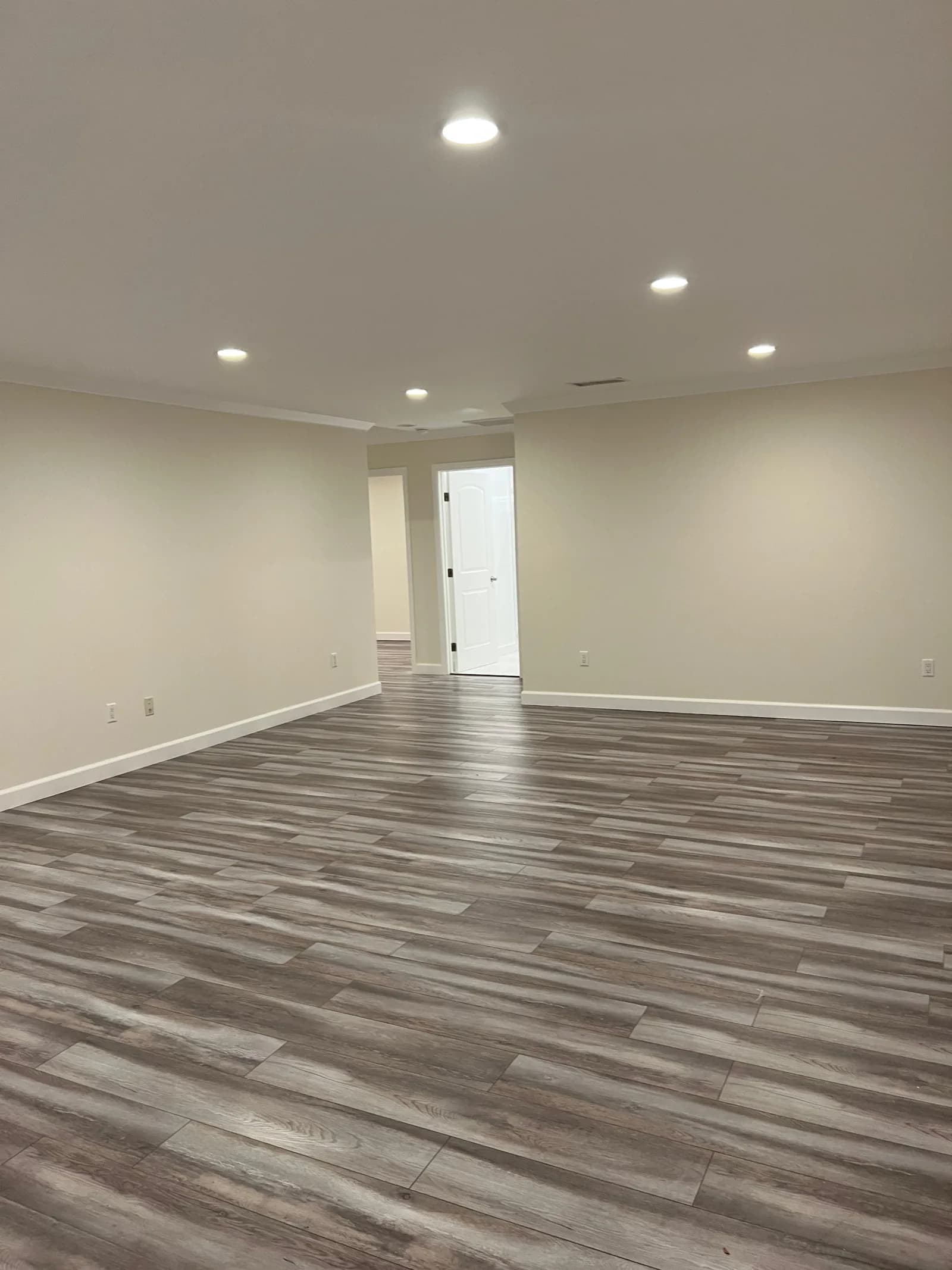 Open living space with luxury vinyl plank flooring and recessed lights